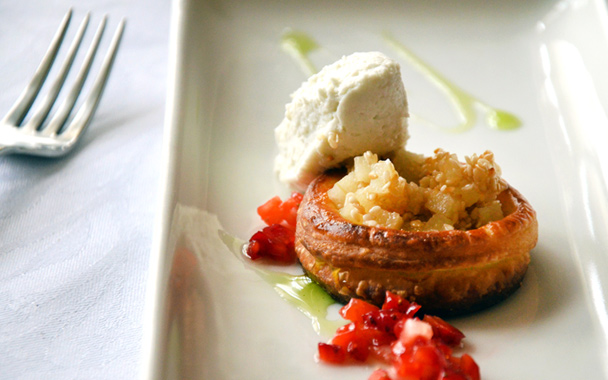A plated dessert stars a flaky, sesame pear tart with diced strawberries and fresh mint oil.